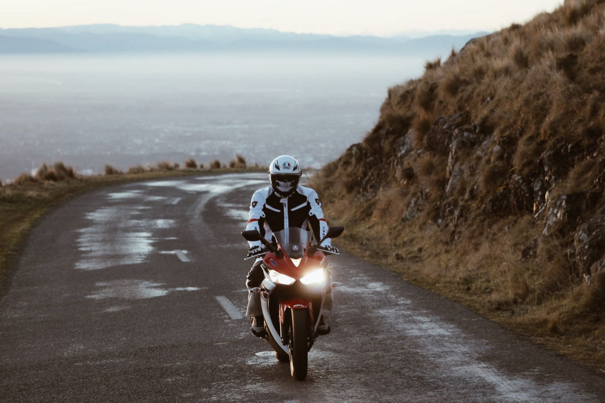 Motociclista recorriendo una carretera junto al mar